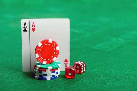 Casino poker chips, dice and cards  on green table background with copy space for your text