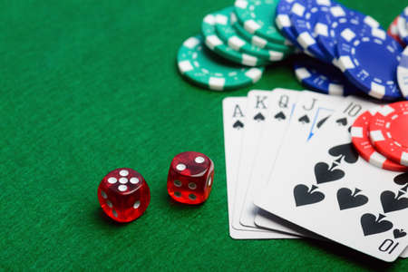 Casino green table with chips, money, play cards and dices. Poker game concept