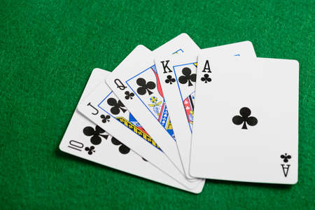 Playing cards flush  on green casino desk  background