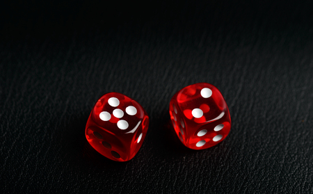 Two dice counting seven on a black leather