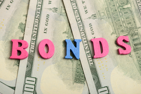 Word bonds at wooden letters on US Dollar billsの写真素材