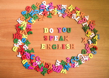 Do you speak english wooden letters around a pile of other over office table board surfaceの写真素材