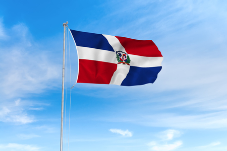 Dominican Republic flag blowing in the wind over nice blue sky backgroundの写真素材