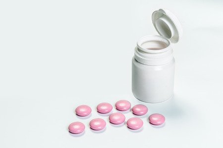 Close up of  tablets and medical bottle on white background