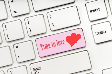 Time to love pink key button on white keyboard concept image