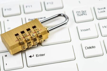 Computer security concept with combination lock padlock on white keyboard