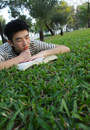 Young man reading in the park の写真素材