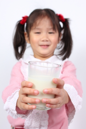Young girl holding glass of milk の写真素材