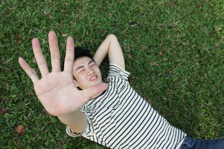 young man in spring grass の写真素材