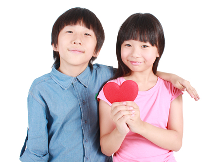 Two happy kids with valentines heart on white background.の写真素材