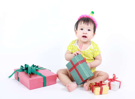 Cute baby laughing wearing party hat, over white background.の写真素材