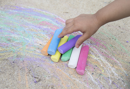 Child's hand with colorful chalk , Colored chalk. Baby's handsの写真素材
