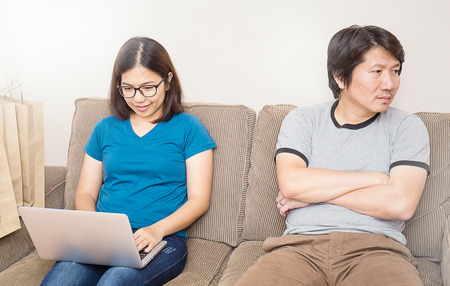Man watching his wife using laptop