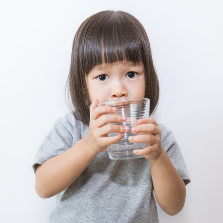 Young little girl drinking water. (water, drink, asian)の写真素材