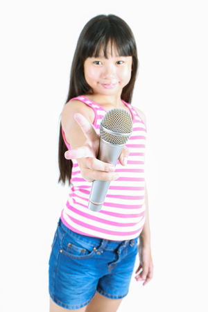 Asian pretty little girl singing with microphone in her handの写真素材