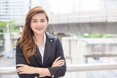 Young Asian executive standing outside office buildingの写真素材