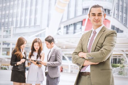 Business manager standing in office leading his teamの写真素材