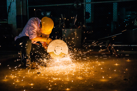 Heavy industry manual worker with grinder background, man wearing mask with his hands grinding in heavy industryの写真素材