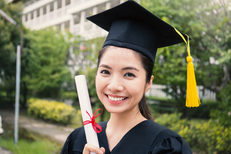 Portrait of young asian woman outside the building on her graduated dayの写真素材