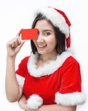 Portrait of Asian beautiful woman wearing Santa costume. Smiling happy Asian girl holding a red credit card. Christmas party and holiday conceptの写真素材