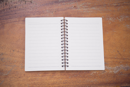 A blank ruled notepad on a desk over wooden, add your own copy.の写真素材