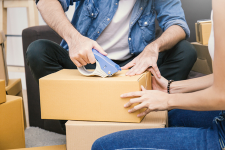Young asian man and woman taping up a cardboard box in the office SME business, relocation and new small business concept, SME conceptの写真素材