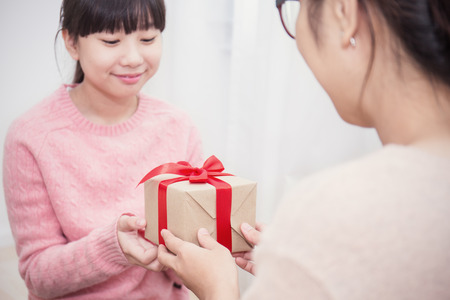 Close up Asian teenage girl surprise her mother with gift box. Boxing day holiday birthday christmas and motherâs day concept.の写真素材