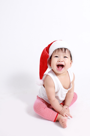 Portrait of happy Asian baby girl with christmas dressing like santa isolated on white backgroundの写真素材
