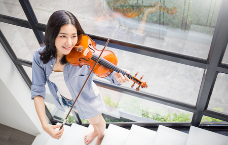 Portrait of beautiful young asian woman playing violin. Education leisure and recreation conceptの写真素材