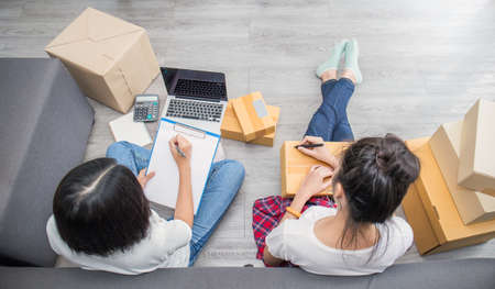 Start up small business entrepreneur SME, asian woman writing address on clipboard box. Portrait of...