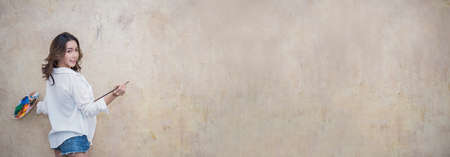 Portrait of asian beautiful sexy woman paint on the wall with copy space banner. Young asian girl...