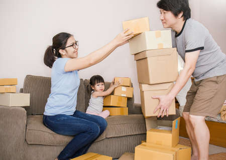 Young asian family man woman and girl packing cardboard box in the office SME business, family...