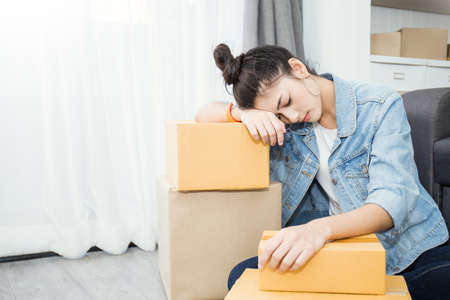 Small business entrepreneur SME freelance asian woman working with box at home concept, Young Asian woman small business owner, online marketing box and delivery, SME bankrupt stress burnout conceptの写真素材