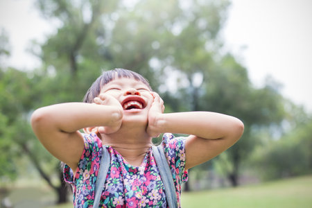 Fun in the park. Portrait of little asian girl having a good happy time in the park. Education green environment spring and summer time conceptの写真素材