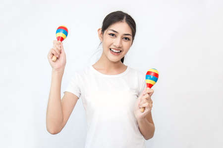 Portrait of beautiful asian woman playing the maracas isolated on white background. Music song...