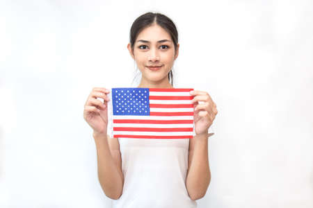 Portrait of beautiful woman holding an American Flag isolated on white background. Independent day fourth of July american people conceptの写真素材
