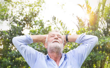 Portrait of healthy happy senior asian old caucasian man in the park outdoors with copy space. Spring healthcare cheerful lifestyle freedom retirement conceptの写真素材