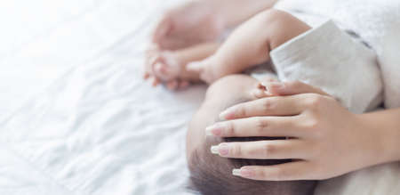 Close up mother hands holding newborn baby head over white background, copy space background, Health care family motherâs day concept bannerの写真素材