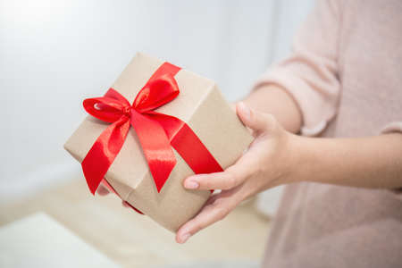 Close up hands giving surprise gift box. Boxing day holiday birthday christmas day concept.