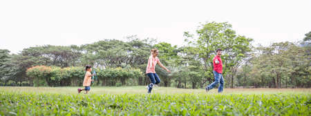 Happy young asian family playing with bubble wands with daughter in park outdoors in summer or spring. Together community love fresh green eco lifestyle concept bannerの写真素材