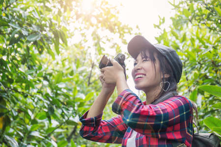 Portrait of young asian girl photographer with camera outdoors at the park. Happy beautiful woman...