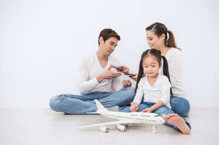 Portrait of happy asian family father mother and daughter having fun playing with airplane. Travel...