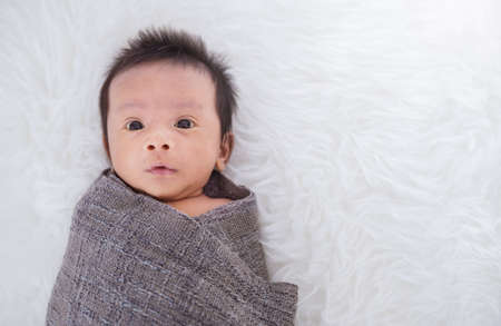 Closeup portrait of asian happy baby wrap up in gray blanket over white background with copy space, Family love newborn healthcare medecal concept.の写真素材