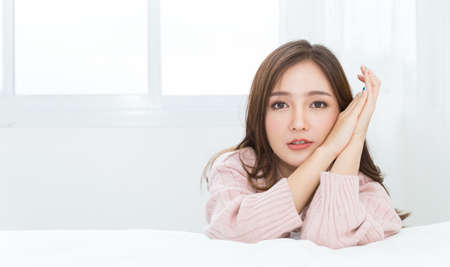 Portrait of young beautiful sexy asian woman relax in her bedroom. Smile happy face asian girl isolated on white background. Beauty treatment perfect clear skin japanese makeup  lifestyle conceptの写真素材