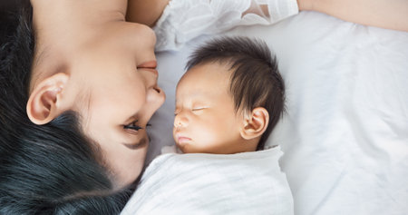 Close up portrait of beautiful young asian mother with her newborn baby, copy space with bed in the hospital background. Healthcare and medical family love lifestyle nursery motherâs day concept bannerの写真素材