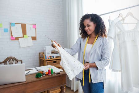 Portrait of beautiful smile african american black designer woman work with computer in tailer...