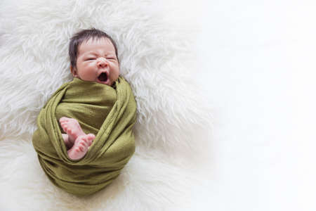 Closeup portrait of asian happy baby wrap up in gray blanket over white background with copy space, Family love newborn healthcare medical concept.の写真素材