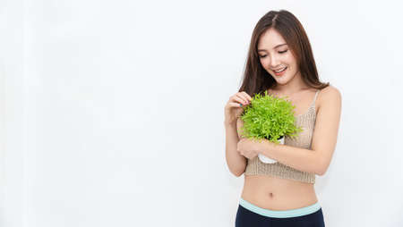 Portrait of young sexy asian korean woman slim fit body hand hold nature green plant isolated on white, asian girl looking. Japanese lifestyle hobby. Slim fit girl next door, earth day conceptの写真素材