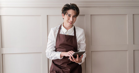 Startup successful small business owner man sme, handsome men in coffee shop restaurant. Portrait of young asian barista cafe local owner hold gadget. SME sell online delivery entrepreneur businessの写真素材