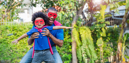 Happy black African American father daughter playing home outdoor. Afro man carry piggyback little toddler super hero boy. Cheerful family bonding together fatherâs day concept banner with copy spaceの写真素材